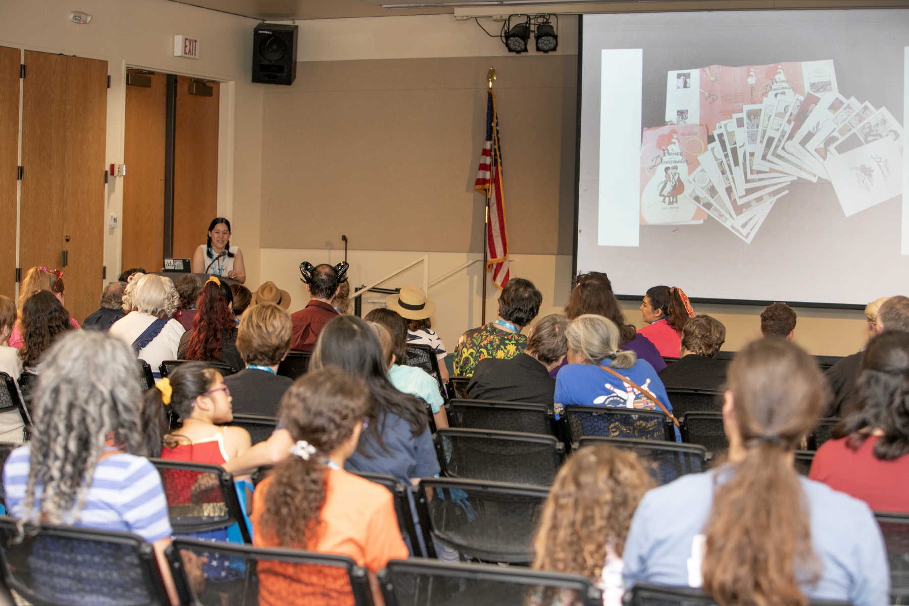 Image of people in a classroom style setting with a screen displaying information. 